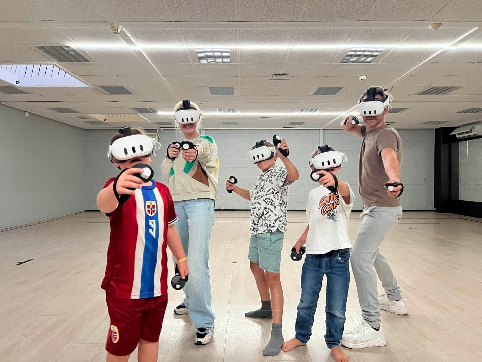 Familie og vennegjeng som spiller VR og utforsker spennende verdener hos KRS VR Arena i Kristiansand